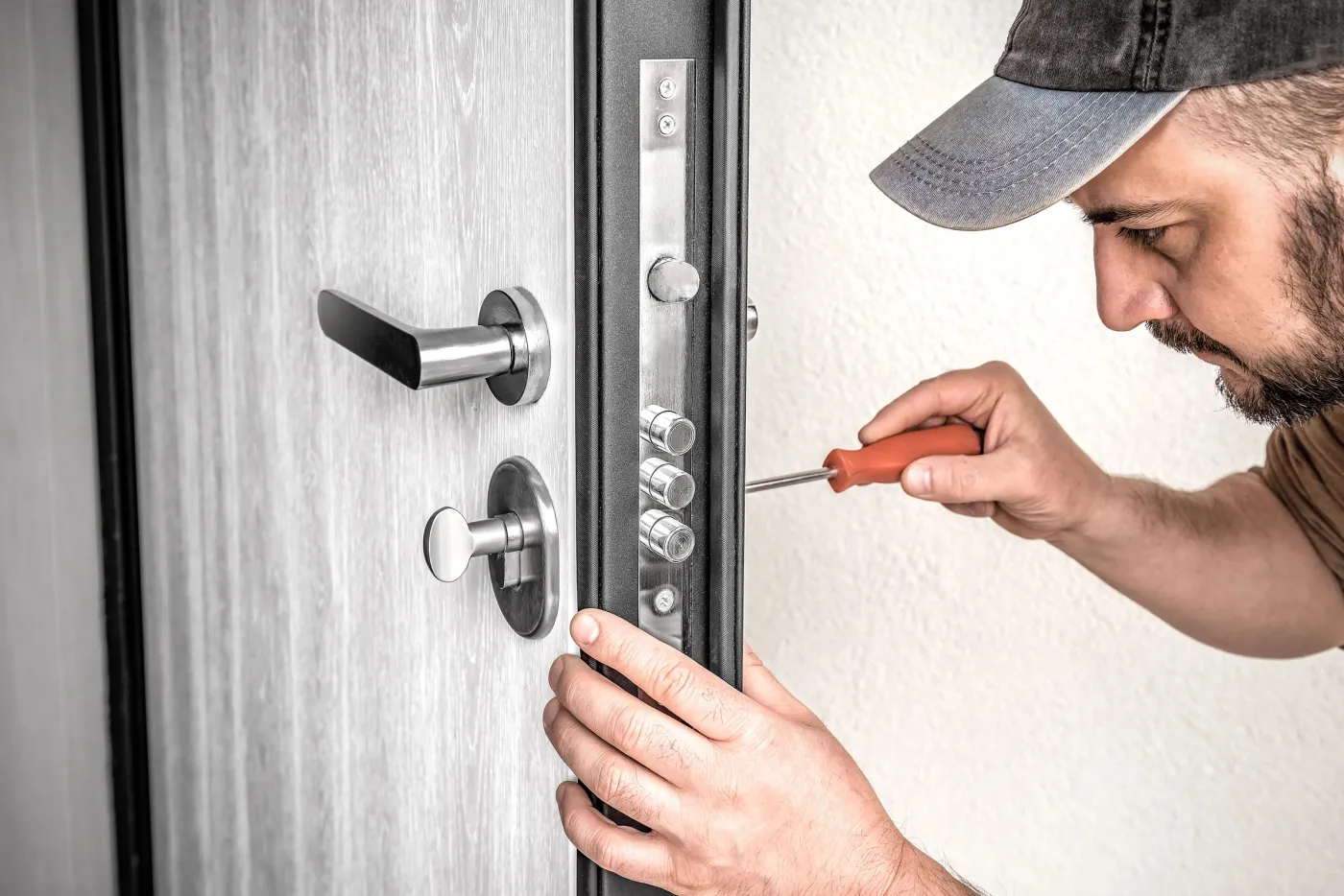 Serrurier installant une serrure multipoints sur une porte blindée